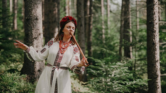 年轻的女人玩木管乐器木长笛乌克兰特伦卡泰林卡森林背景人音乐概念音乐的仪器音乐家传统的绣花衬衫维希万卡