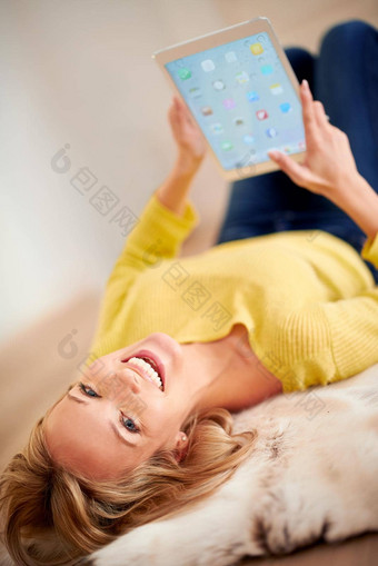 最后发现平板电脑好健康年轻的女人笑幸福的说谎地板上持有数字平板电脑