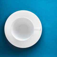白色餐具陶器集空杯蓝色的平铺背景