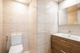 简单的浴室白色厕所。。。木家具米色瓷砖现代室内翻新公寓