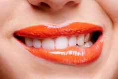 妍普通的橙色女人咬橙色彩色的嘴唇
