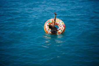 年轻的女人浮动充气大甜甜圈透明的绿松石海视图纤细的夫人放松假期火鸡埃及地中海海