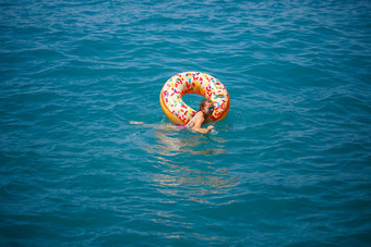 年轻的女人浮动充气大甜甜圈透明的绿松石海视图纤细的夫人放松假期火鸡埃及地中海海