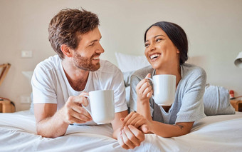 夫妇咖啡跨种族微笑放松床上房子微笑爱婚姻有趣的沟通卧室首页男人。女人快乐茶喝漫画谈话早....