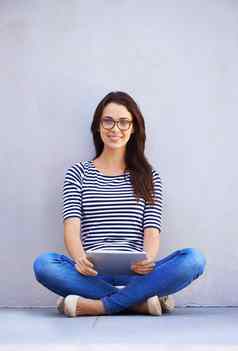 生活生活连接有吸引力的年轻的女人坐着盘腿地板上数字平板电脑
