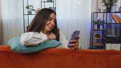 肖像成人女孩坐着沙发智能手机分享消息社会媒体应用程序