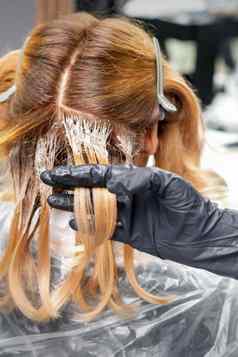 理发师应用颜色头发黑色的手套头发着色美沙龙美概念