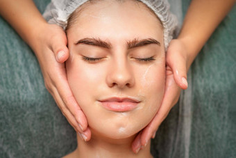 水疗中心面部护肤品特写镜头年轻的高加索人女人水疗中心保湿脸按摩治疗美水疗中心沙龙