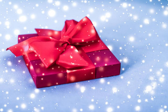 圣诞节假期奢侈品红色的礼物盒子蓝色的背景发光的雪闪闪发光的