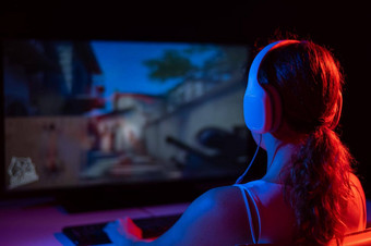 后视图高加索人女人玩电脑游戏霓虹灯光黑暗