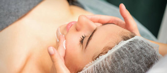 水疗中心面部护肤品特写镜头年轻的高加索人女人水疗中心保湿脸按摩治疗美水疗中心沙龙