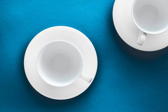 白色餐具陶器集空杯蓝色的平铺背景