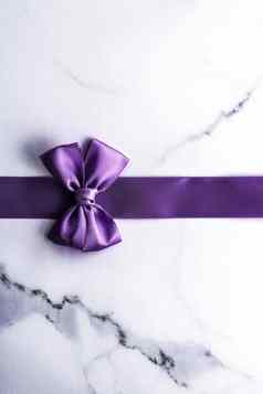 紫色的丝绸丝带弓奢侈品大理石背景假期平铺背景