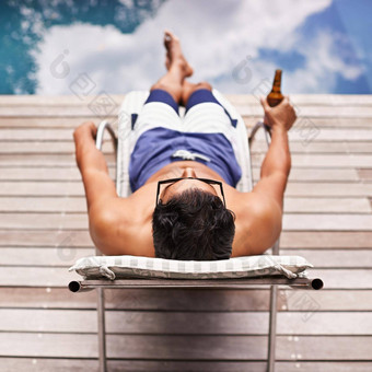 最终放松后视图拍摄年轻的男人。躺池啤酒