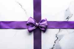 紫色的丝绸丝带弓奢侈品大理石背景假期平铺背景