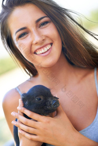 最新的成员农场年轻的女人持有可爱的小猪