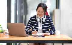 学生学习移动PC在室内教育培训研讨会教育在线概念亚洲女人现代移动PC耳机学习首页