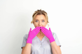 肖像年轻的<strong>女</strong>高加索人医生护士震惊了覆盖口粉红色的戴着手套手白色背景