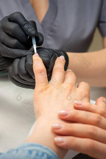 绘画女指甲手指甲修饰师黑色的手套应用透明的指甲波兰的女指甲修指甲沙龙