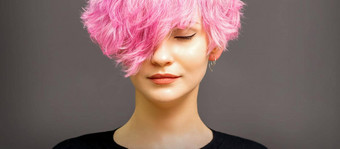 美丽的年轻的高加索人女人短卷曲的鲍勃发型染色粉红色的颜色关闭眼睛黑暗灰色的背景复制空间