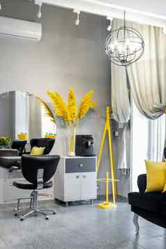 现代小明亮的头发美沙龙黑色的黄色的颜色灰色的墙地板上黑色的沙发黄色的垫子