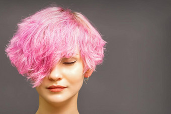美丽的年轻的高加索人女人短卷曲的鲍勃发型染色粉红色的颜色关闭眼睛黑暗灰色的背景复制空间