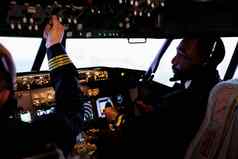 多民族团队飞行员控制面板驾驶舱飞飞机