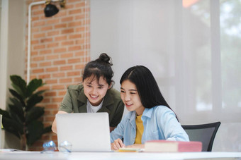 年轻的亚洲大学学生研究学习讨论工作电脑