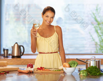 干杯好食物年轻的女人持有玻璃酒烹饪