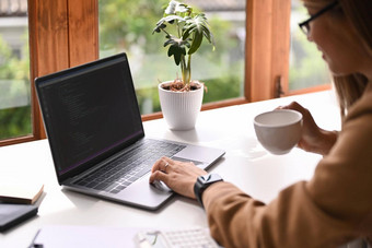 女<strong>软件开发</strong>人员喝咖啡工作编码数据企业办公室