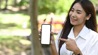 微笑年轻的女人持有模拟聪明的电话空白屏幕