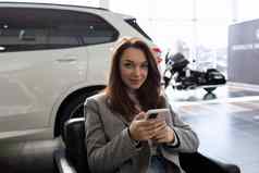 年轻的女人车经销商等待销售经理汽车