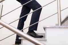 特写镜头腿商人攀爬楼梯概念成功的业务职业生涯增长