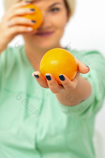 微笑女营养学家持有橙色提供相机白色背景健康的饮食概念