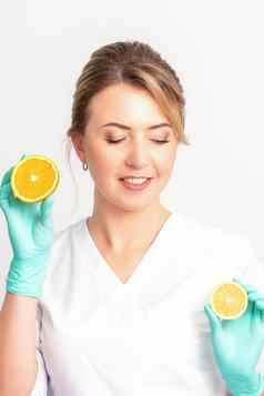 微笑女营养学家持有切片橙色相机白色背景健康的饮食概念