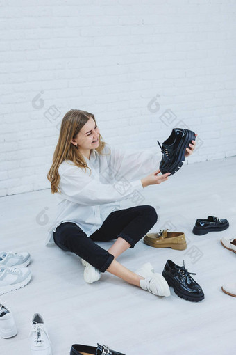 女人坐在地板上沙拉酱房间鞋子选择鞋子夫人白色衬衫女人白色鞋子
