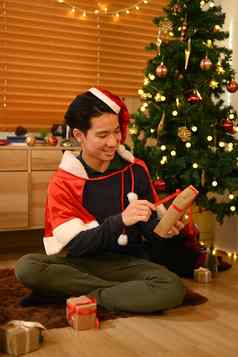 男人。圣诞老人他开放圣诞节礼物坐着装饰房间假期庆祝活动概念