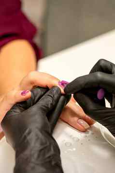 专业修指甲指甲修饰师绘画女指甲客户端紫色的指甲波兰的美沙龙关闭美行业概念