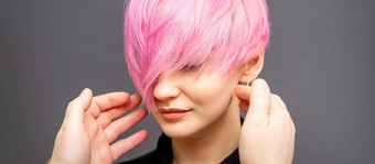理发师手检查修复短粉红色的发型年轻的白色女人头发沙龙