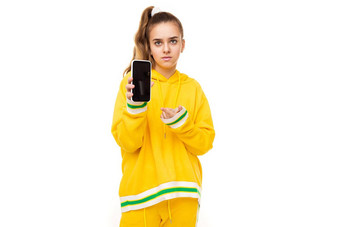 照片美丽的女孩黑暗头发马尾辫时尚的黄色的运动服绿色条纹显示移动电话黑色的空白显示孤立的白色背景免费的空间文本