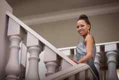 美爬楼梯肖像有吸引力的年轻的女人微笑站楼梯