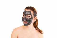 年轻的女人淋浴黑色的化妆品面具脸使粘土