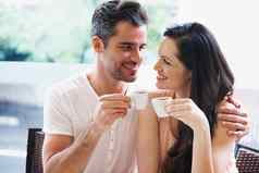 爱年轻的夫妇抓住杯咖啡