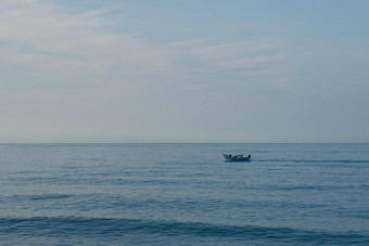 简单的背景平静黑暗蓝色的海钓鱼船白色苍白的浪花云开放限制