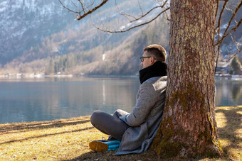 年轻的男人。坐着在户外享受山雪湖好天气蓝色的天空太阳美丽的景观时间做<strong>梦</strong>放松精神<strong>健康</strong>旅游假期旅行