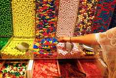 女人手独家新闻采取色彩斑斓的美味的糖果计数器商店杂货店市场咖啡馆