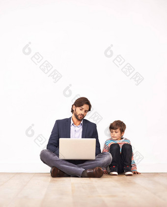 现代育儿父亲年轻的儿子坐着地板上移动PC