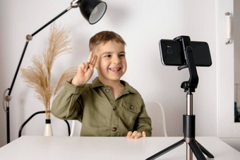 可爱的可爱的男孩博主记录生活方式博客会说话的相机智能手机三脚架年轻的影响者拍摄视频博客通道孩子使视频追随者在线