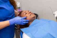 黑色的女人病人铺设牙科椅子之前治疗