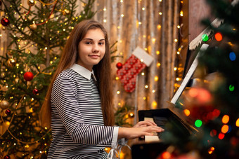 年轻的女钢琴家长头发衣服坐着计划相机